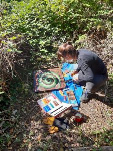Woman painting a snake on a hibernacula