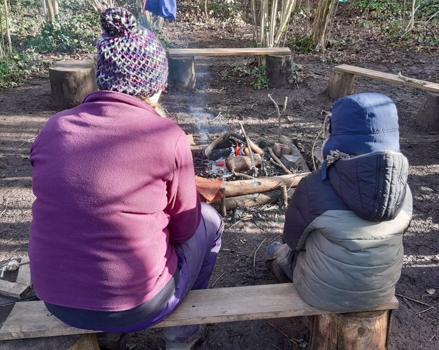 adult and child sharing a thoughtful moment by the camp fire